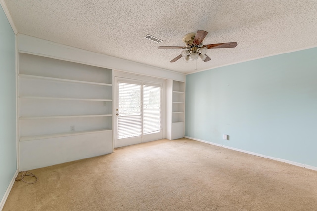 empty room with a textured ceiling, carpet floors, and ceiling fan