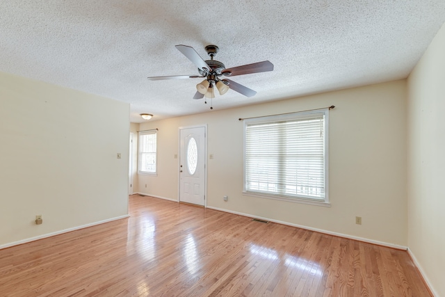 entrance foyer featuring ceiling fan, a textured ceiling, and light hardwood / wood-style flooring