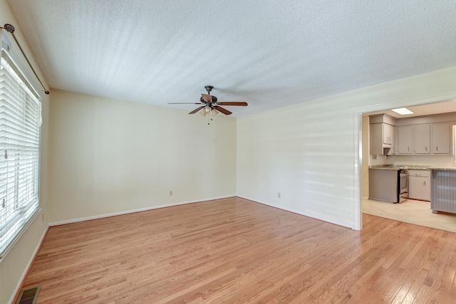 unfurnished living room featuring light hardwood / wood-style floors, a textured ceiling, and ceiling fan