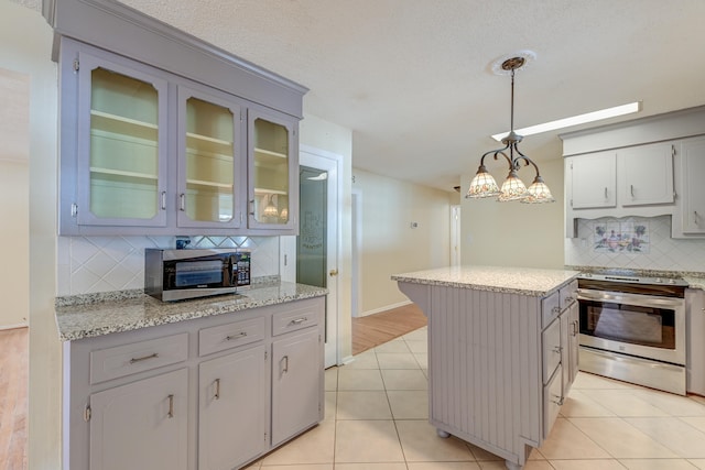 kitchen featuring tasteful backsplash, light hardwood / wood-style flooring, stainless steel appliances, decorative light fixtures, and a center island