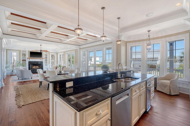 kitchen with dark wood-type flooring, open floor plan, a sink, dishwasher, and a lit fireplace