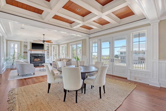 dining room featuring french doors, plenty of natural light, coffered ceiling, and a decorative wall