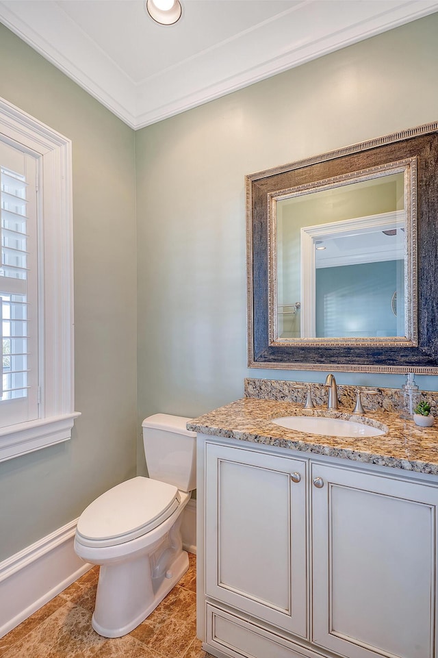 bathroom featuring ornamental molding, vanity, and toilet