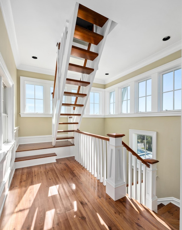 stairs featuring baseboards, hardwood / wood-style flooring, and crown molding