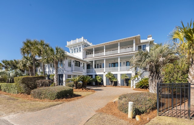 view of property featuring stairs and decorative driveway