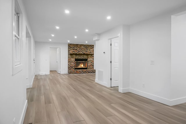 unfurnished living room featuring light hardwood / wood-style flooring and a fireplace