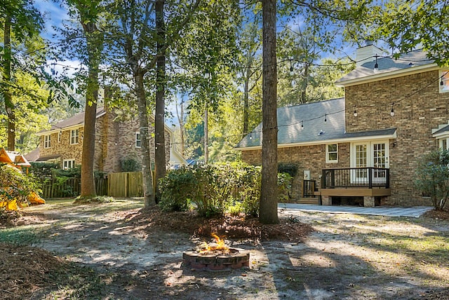 view of yard featuring a deck and a fire pit