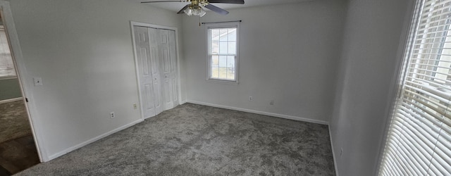 unfurnished bedroom with ceiling fan, dark carpet, and a closet