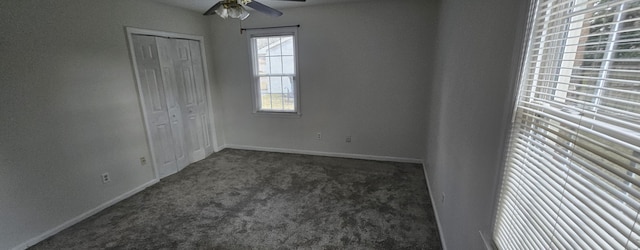 unfurnished bedroom featuring ceiling fan, dark carpet, and a closet