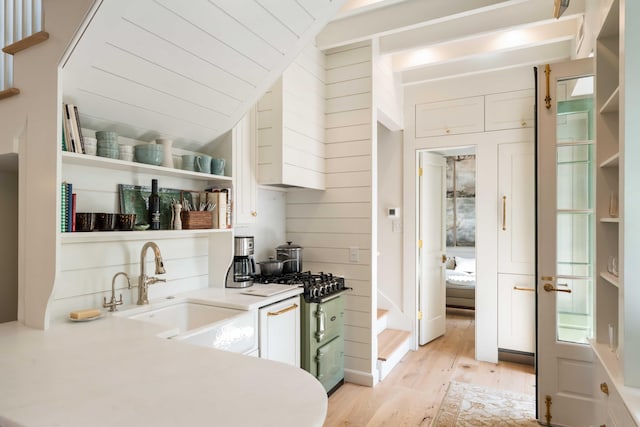 bar featuring vaulted ceiling, a sink, and light wood finished floors