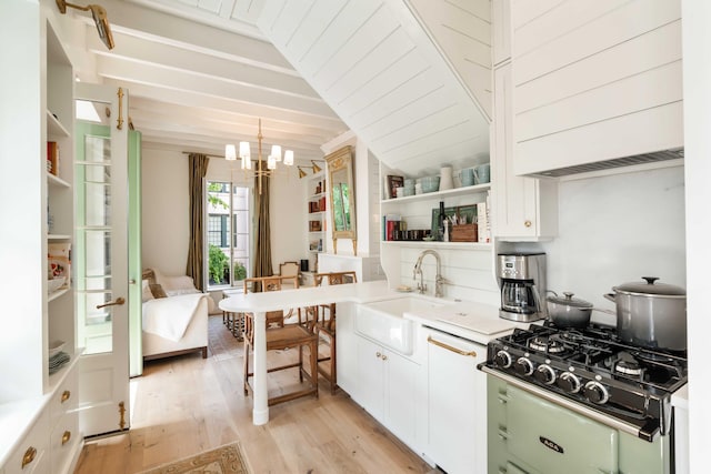 kitchen featuring an inviting chandelier, open shelves, a sink, white cabinets, and light wood-style floors
