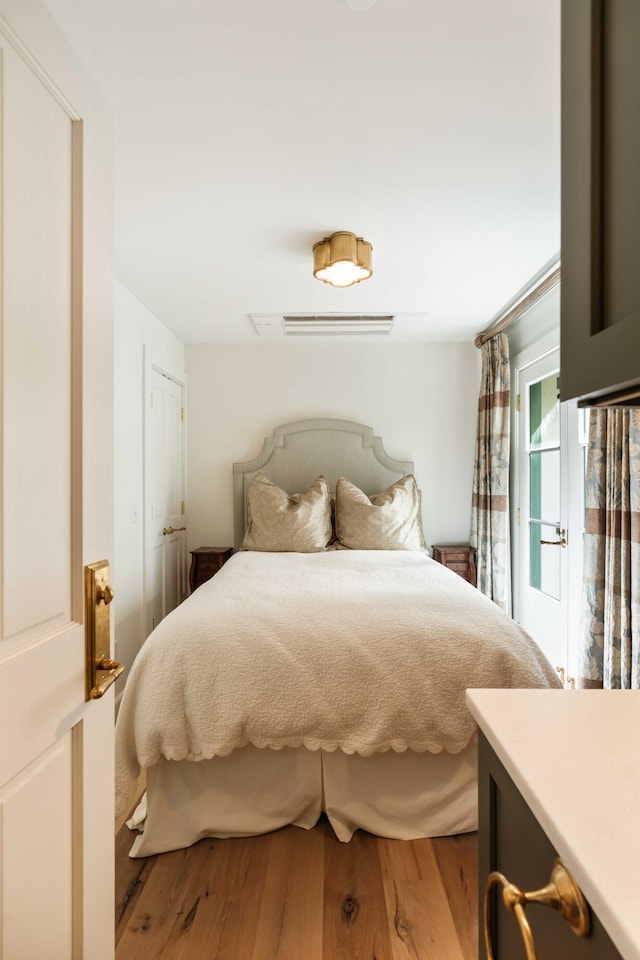 bedroom featuring access to outside and wood finished floors