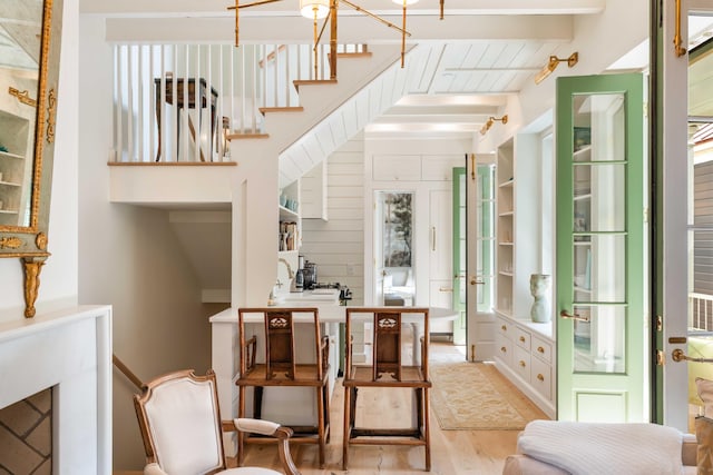 interior space featuring stairway, light wood-type flooring, and beam ceiling