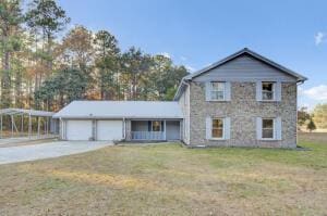 view of front of home with a carport, a garage, and a front yard