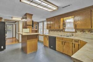 kitchen featuring sink, a kitchen island, and black appliances