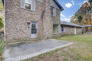 rear view of house with a patio and a lawn