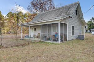 back of house with a sunroom, central AC, and a lawn