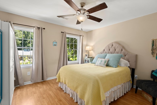 bedroom with multiple windows, ceiling fan, and light wood-type flooring