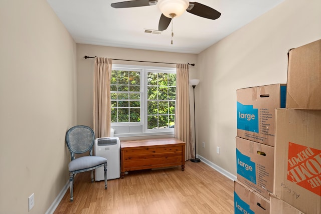 living area with light hardwood / wood-style floors and ceiling fan