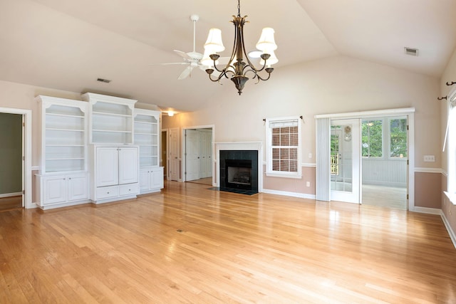 unfurnished living room featuring a fireplace, vaulted ceiling, ceiling fan with notable chandelier, and light hardwood / wood-style flooring