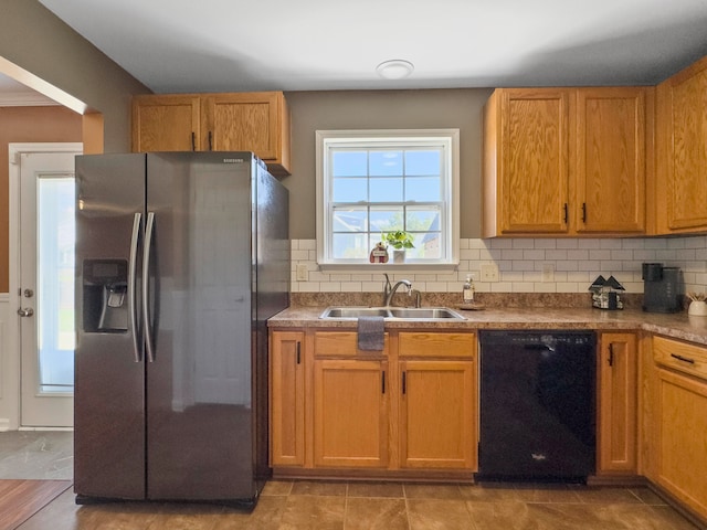 kitchen with sink, black dishwasher, stainless steel refrigerator with ice dispenser, decorative backsplash, and light tile patterned flooring