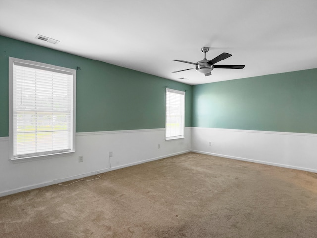 carpeted spare room featuring ceiling fan