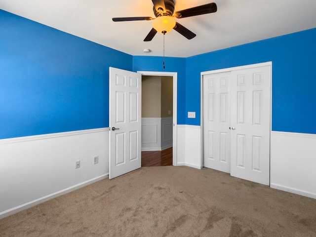 unfurnished bedroom featuring carpet, ceiling fan, and a closet