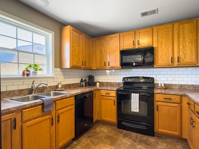 kitchen featuring backsplash, sink, dark tile patterned floors, and black appliances