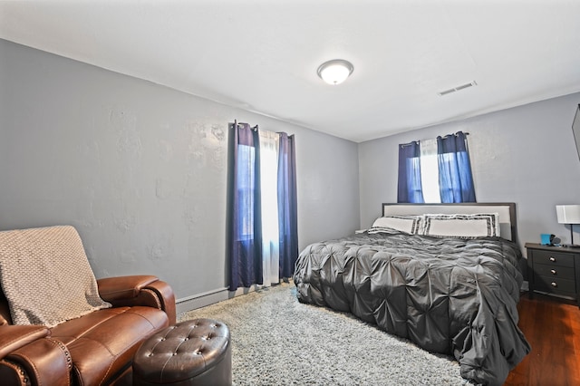 bedroom with multiple windows and dark wood-type flooring