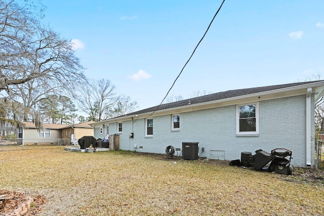 back of house featuring central AC unit and a yard