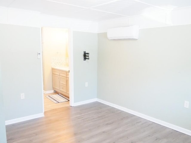 empty room with light hardwood / wood-style floors and an AC wall unit