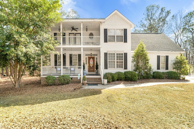 view of front facade with a porch, roof with shingles, ceiling fan, and a balcony