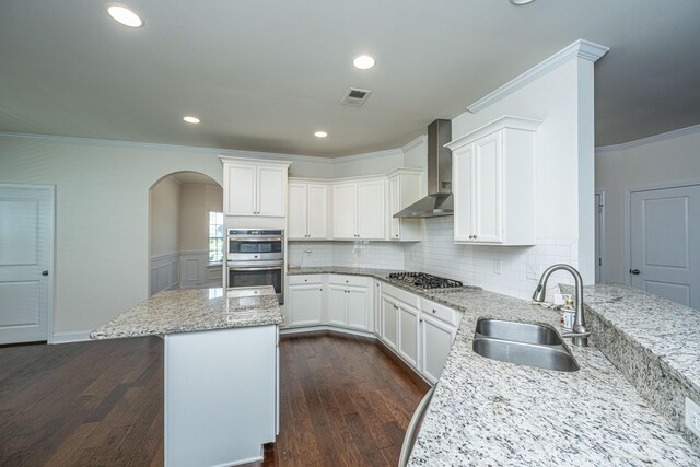 9710 Table Mountain Ln, Ladson, SC 29456 - kitchen with wall chimney exhaust hood, stainless steel appliances, crown molding, light stone countertops, and dark wood-style flooring