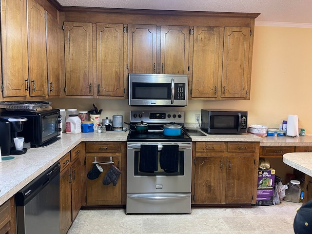 kitchen with a textured ceiling, appliances with stainless steel finishes, and crown molding