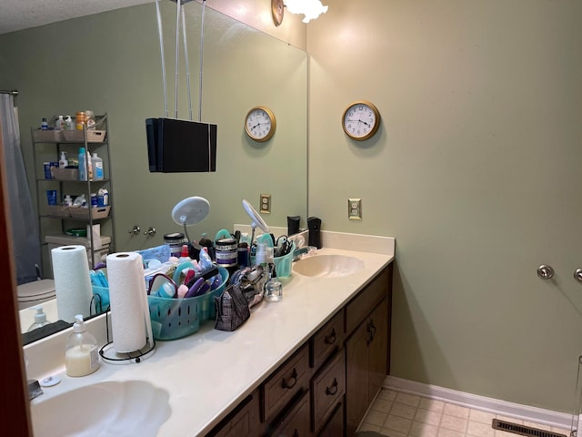 bathroom featuring vanity, toilet, and a textured ceiling