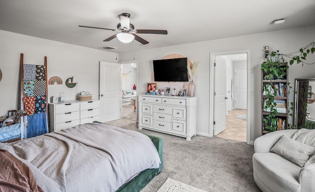 bedroom with visible vents, connected bathroom, baseboards, ceiling fan, and light colored carpet