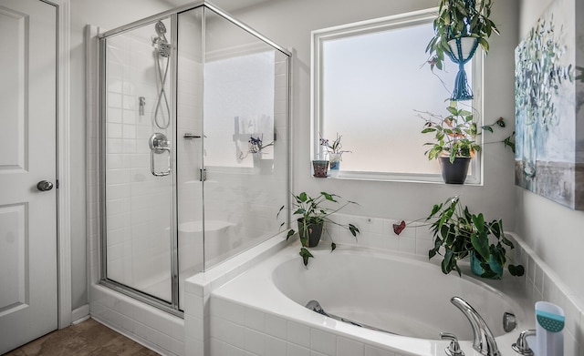 full bathroom featuring a bath and a stall shower