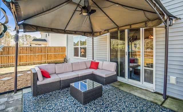 view of patio featuring a gazebo, an outdoor living space, and fence