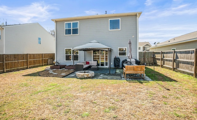 rear view of house with a gazebo, a yard, a patio, and a fenced backyard