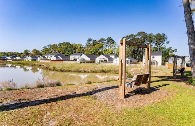 view of yard with fence, a residential view, and a water view