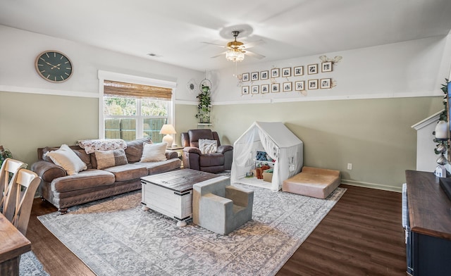 living area with visible vents, baseboards, a ceiling fan, and dark wood-style flooring