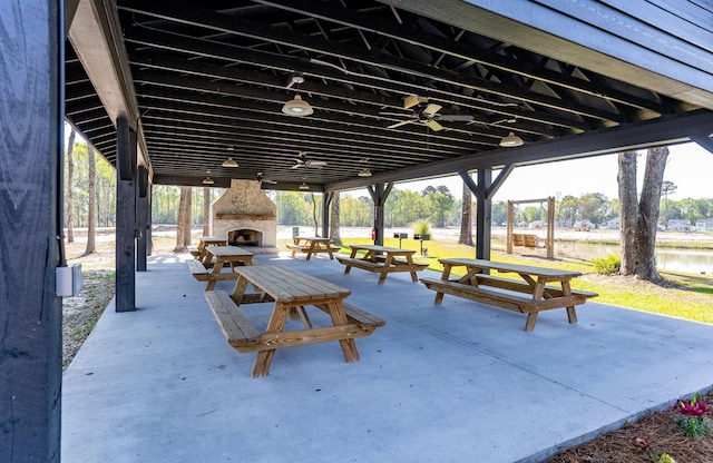 view of patio with an outdoor stone fireplace and ceiling fan