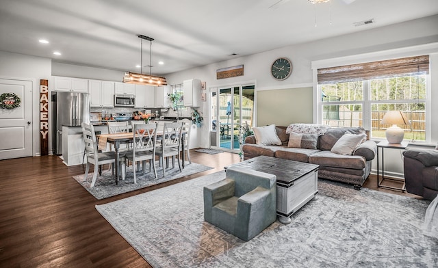 living area with recessed lighting, visible vents, and dark wood-type flooring