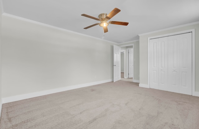 unfurnished bedroom with a closet, ceiling fan, crown molding, and light colored carpet