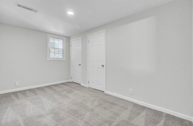 unfurnished bedroom with light colored carpet