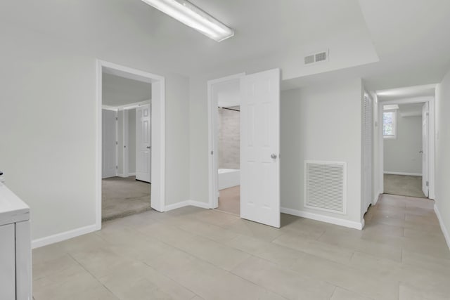 unfurnished bedroom featuring light tile patterned floors and ensuite bathroom