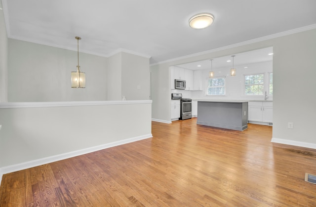 unfurnished living room featuring crown molding, light hardwood / wood-style flooring, and sink