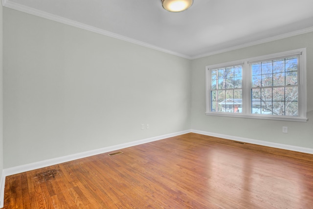 spare room with ornamental molding and hardwood / wood-style flooring