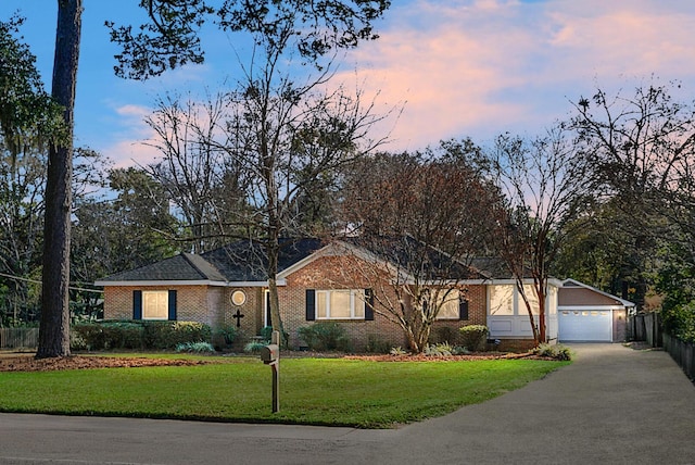 ranch-style house featuring a garage and a yard