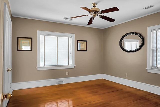 empty room featuring ceiling fan, ornamental molding, and hardwood / wood-style flooring